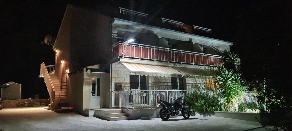 Una motocicleta estacionada frente a un edificio por la noche en Luxury apartments Oasis, en Lumbarda