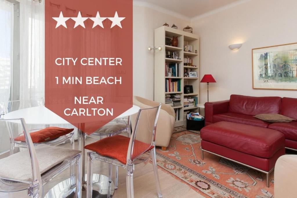 un salon avec un canapé rouge et une table dans l'établissement 2-Br Apartment in City Center, à Cannes