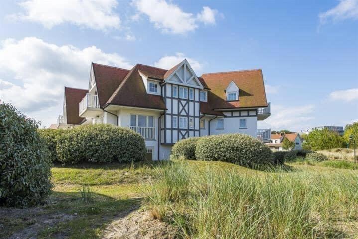 a large white house with a brown roof at EastDune in Oostduinkerke