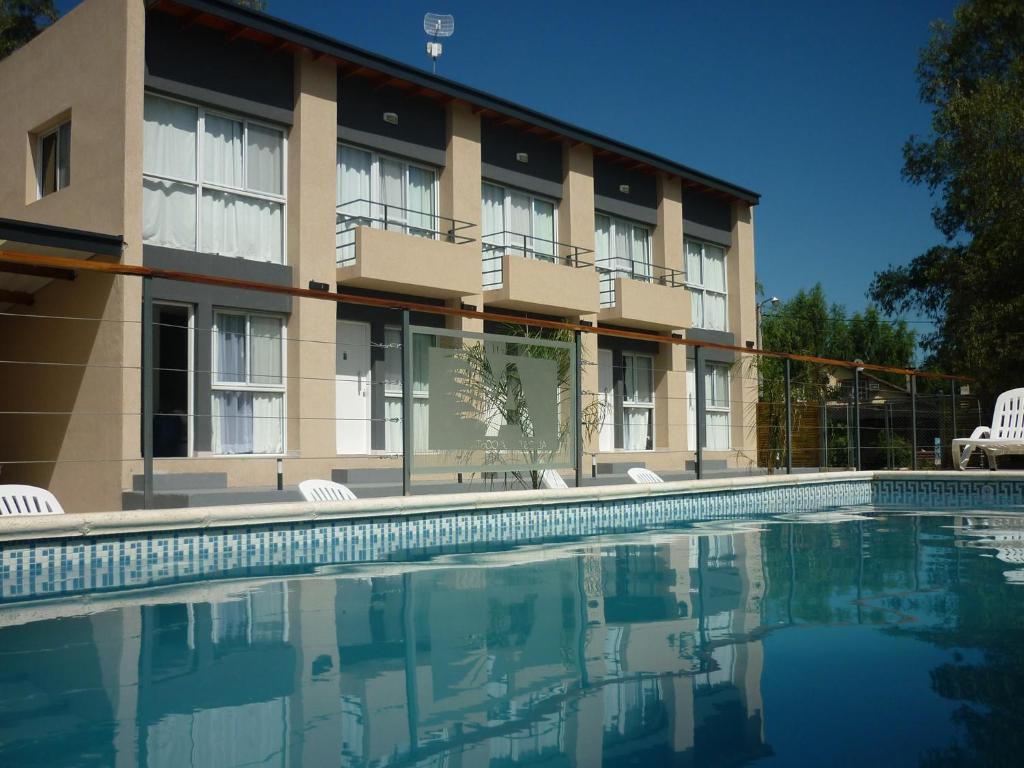 a hotel with a swimming pool in front of a building at Altos de la Costa - Gualeguaychú in Gualeguaychú