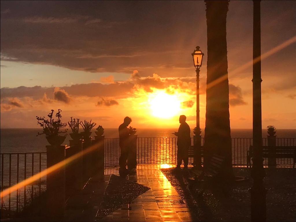 two people standing on a balcony watching the sunset at Nereide in Tropea