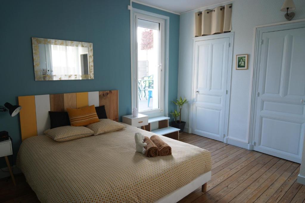 ein Schlafzimmer mit einem Bett mit einem ausgestopften Tier darauf in der Unterkunft 72m² avec terrasse dans demeure angevine de 2 étages in Angers