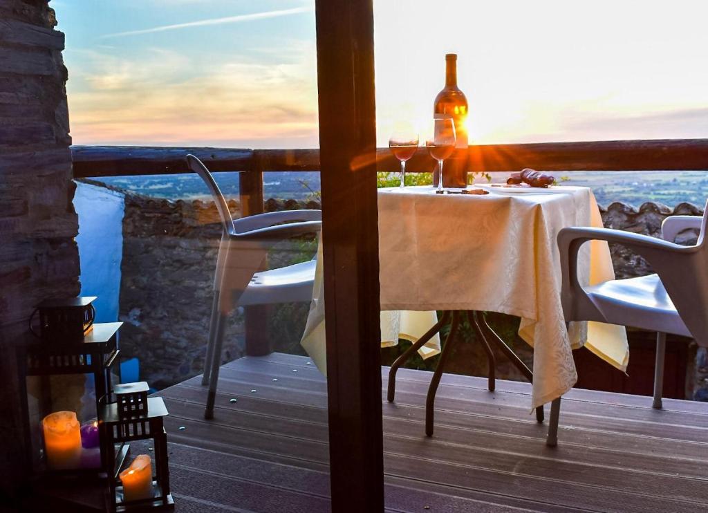 een tafel met een fles wijn op een balkon bij Casa D’ Santiago in Monsaraz