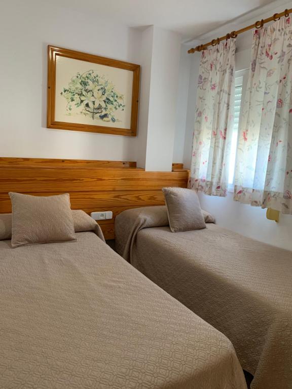 ein Schlafzimmer mit 2 Betten und einem Bild an der Wand in der Unterkunft Apartamentos La Proa in Torremolinos