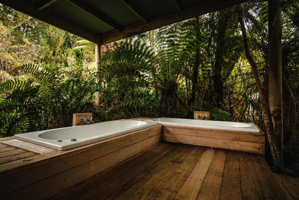 bañera en la parte superior de una terraza de madera en Franz Josef Treetops en Franz Josef