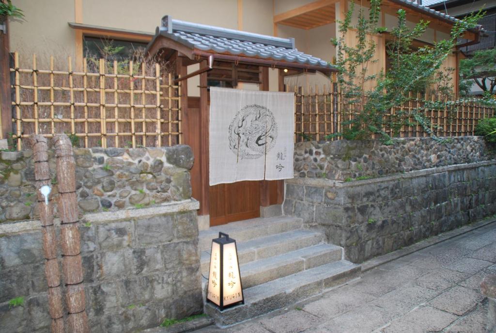 a light on the side of a building with a fence at Small Luxury Ryugin in Kyoto