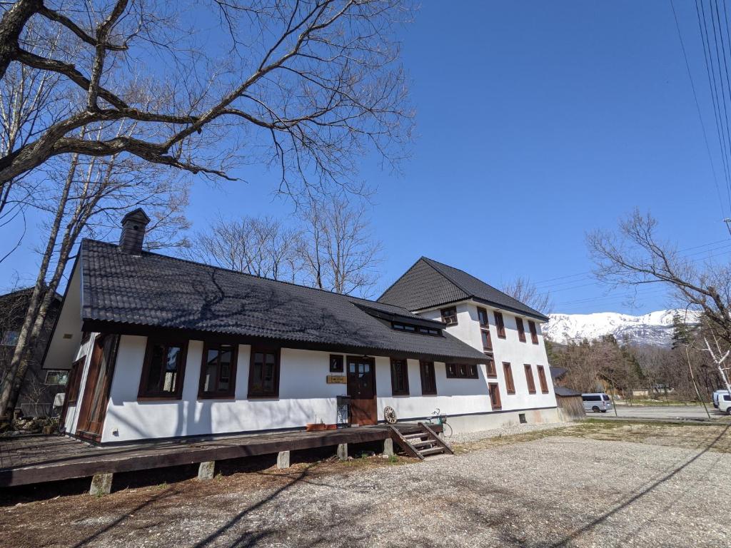 une maison blanche avec un toit noir dans l'établissement The Joint, à Hakuba