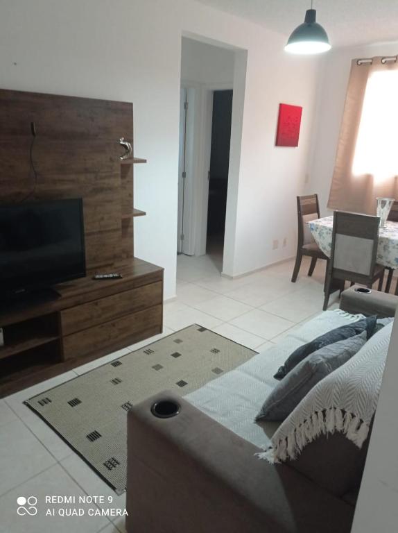 a living room with a couch and a flat screen tv at Aluguel Agua Marinha in Campos dos Goytacazes