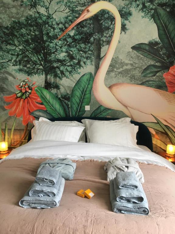 una cama con toallas y una pintura de un flamenco en B&B Koeketiene, en Gante