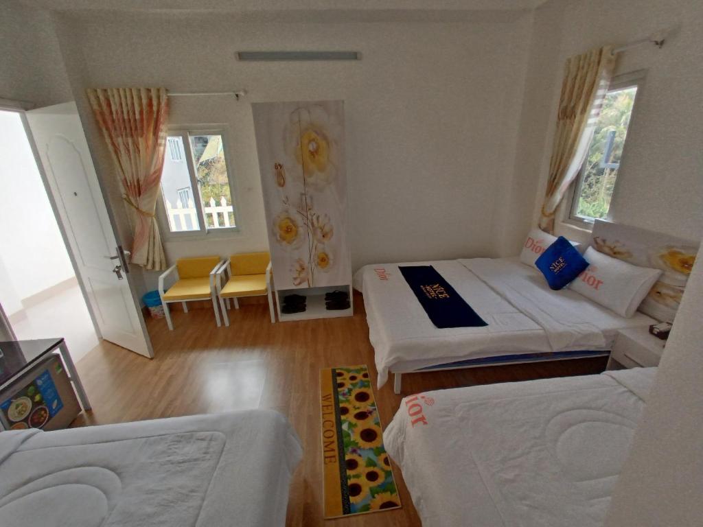 Habitación con 2 camas y sala de estar. en Onhotel Nice Buôn Ma Thuột en Buon Ma Thuot