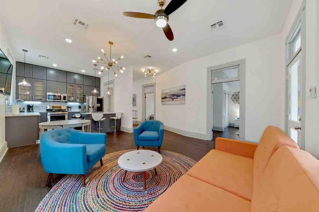 Una sala de estar con un sofá y sillas y una cocina. en Historic home with heated Mini Pool walking distance to downtown San Antonio!, en San Antonio