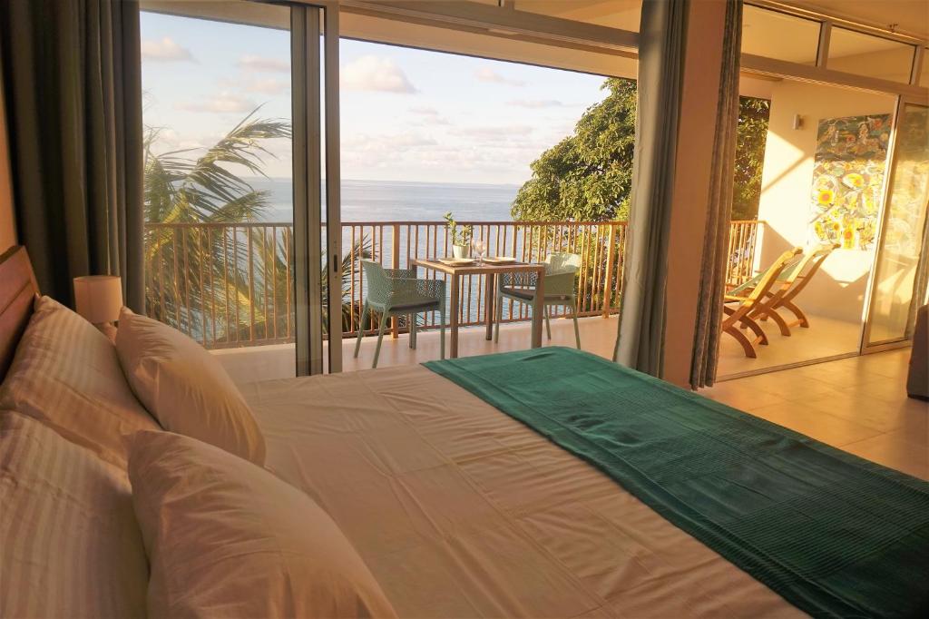 a bedroom with a bed and a view of the ocean at Maka Bay Self Catering in Victoria