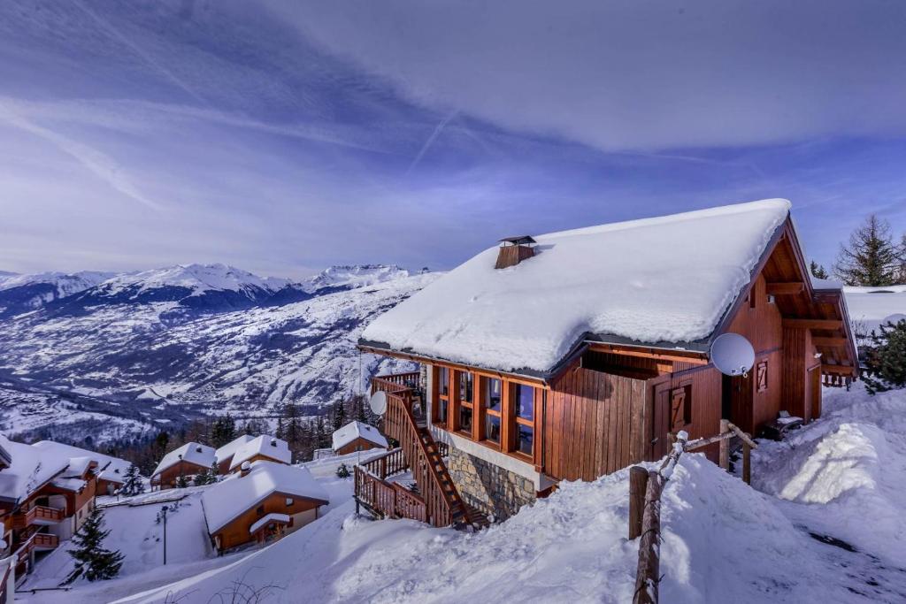 Cabaña cubierta de nieve en la cima de una montaña nevada en La Couronne, en Peisey-Nancroix