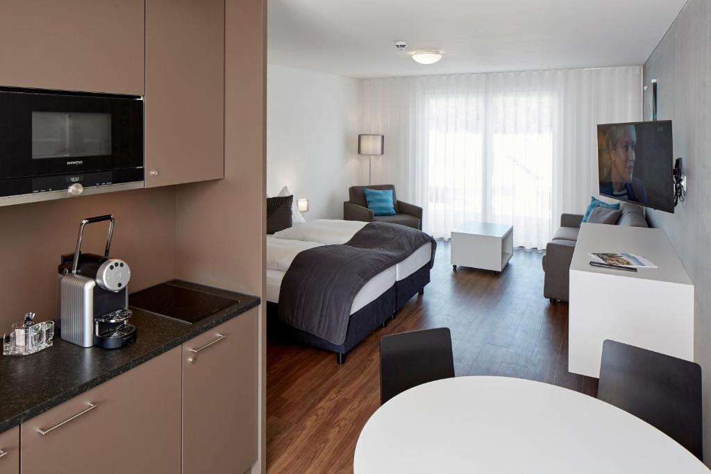 バーデンにあるAparthotel Badenのベッドとリビングルームが備わるホテルルームです。