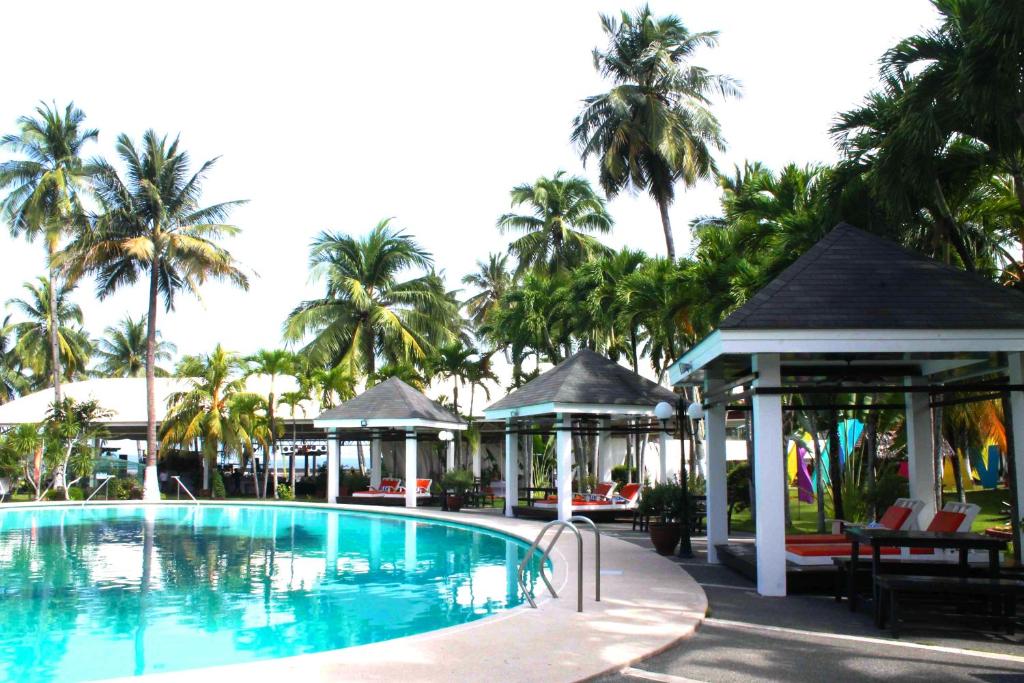 a swimming pool with a gazebo and palm trees at Waterfront Insular Hotel Davao in Davao City