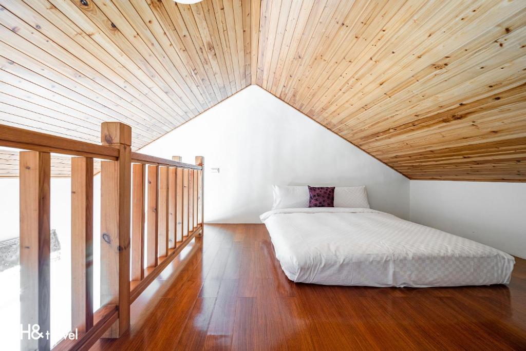 a bed in a room with a wooden ceiling at Shan Tyi Homestay in Ji&#39;an