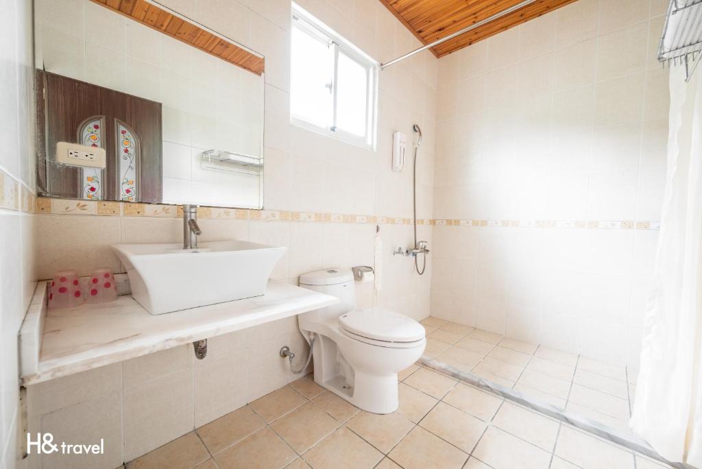 a bathroom with a toilet and a sink and a window at Shan Tyi Homestay in Ji&#39;an