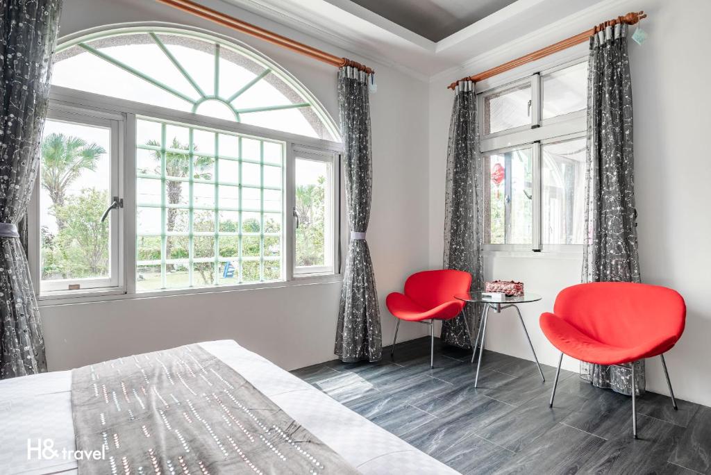 a bedroom with two red chairs and a window at Shan Tyi Homestay in Ji&#39;an