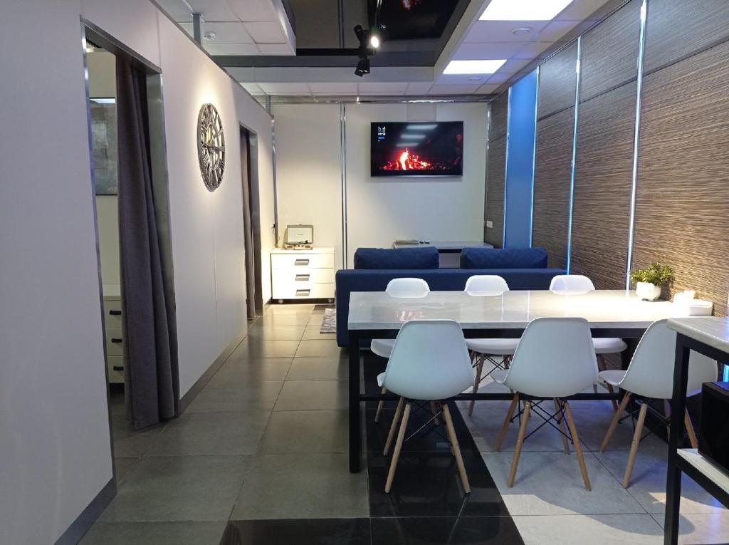 a dining room with a white table and white chairs at Ost-roff Hotel in Izhevsk