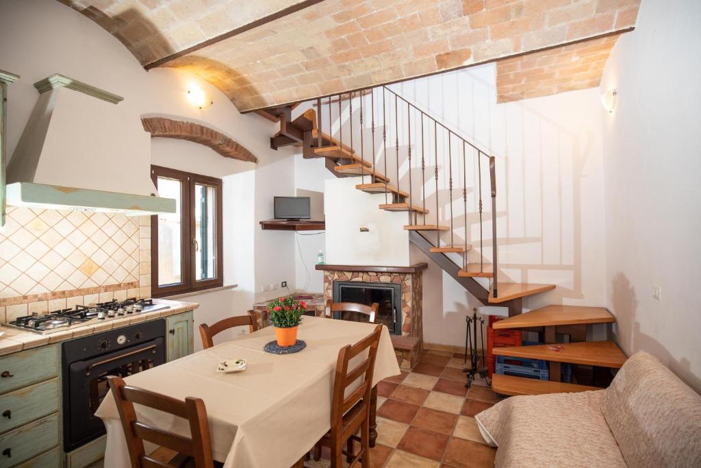 a kitchen and dining room with a table and a staircase at CasaMatta2 in Isola del Giglio