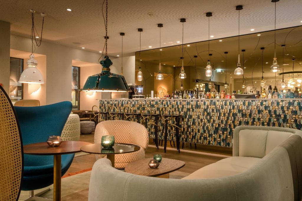 ein Restaurant mit Tischen und Stühlen und eine Bar in der Unterkunft Motel One Linz-Hauptplatz in Linz