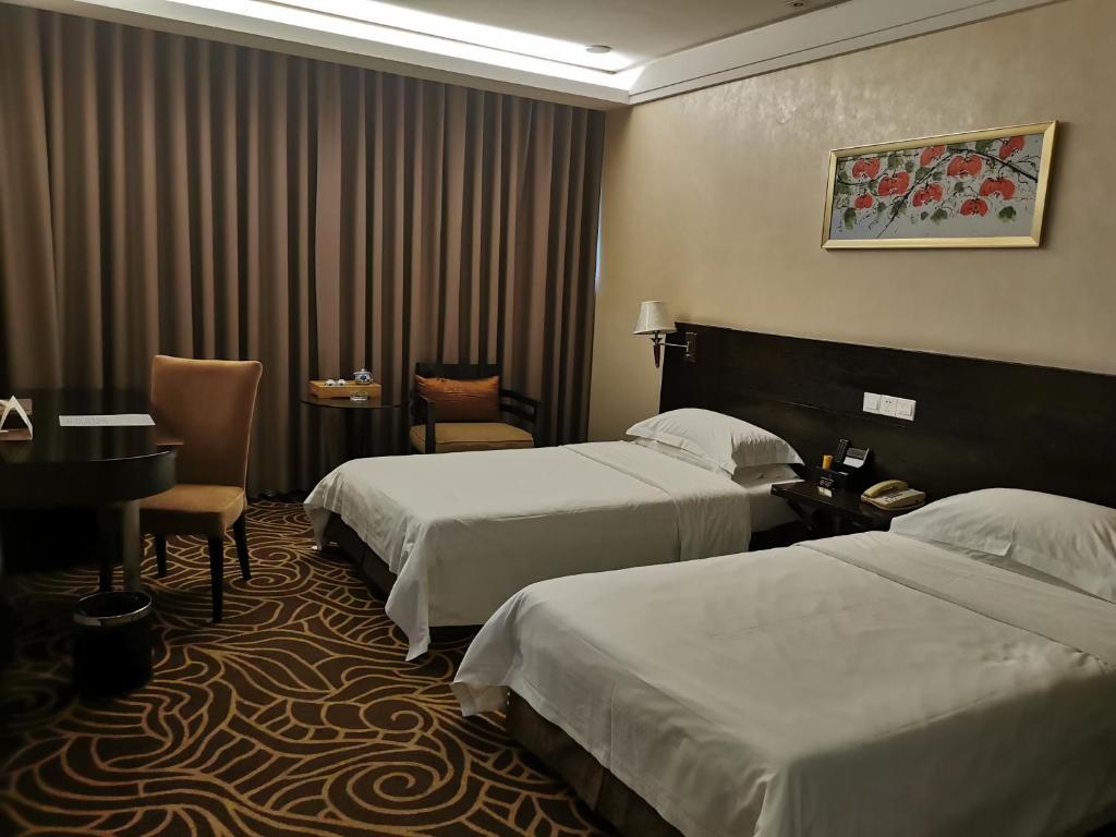 Postel nebo postele na pokoji v ubytování Hua Shi Hotel