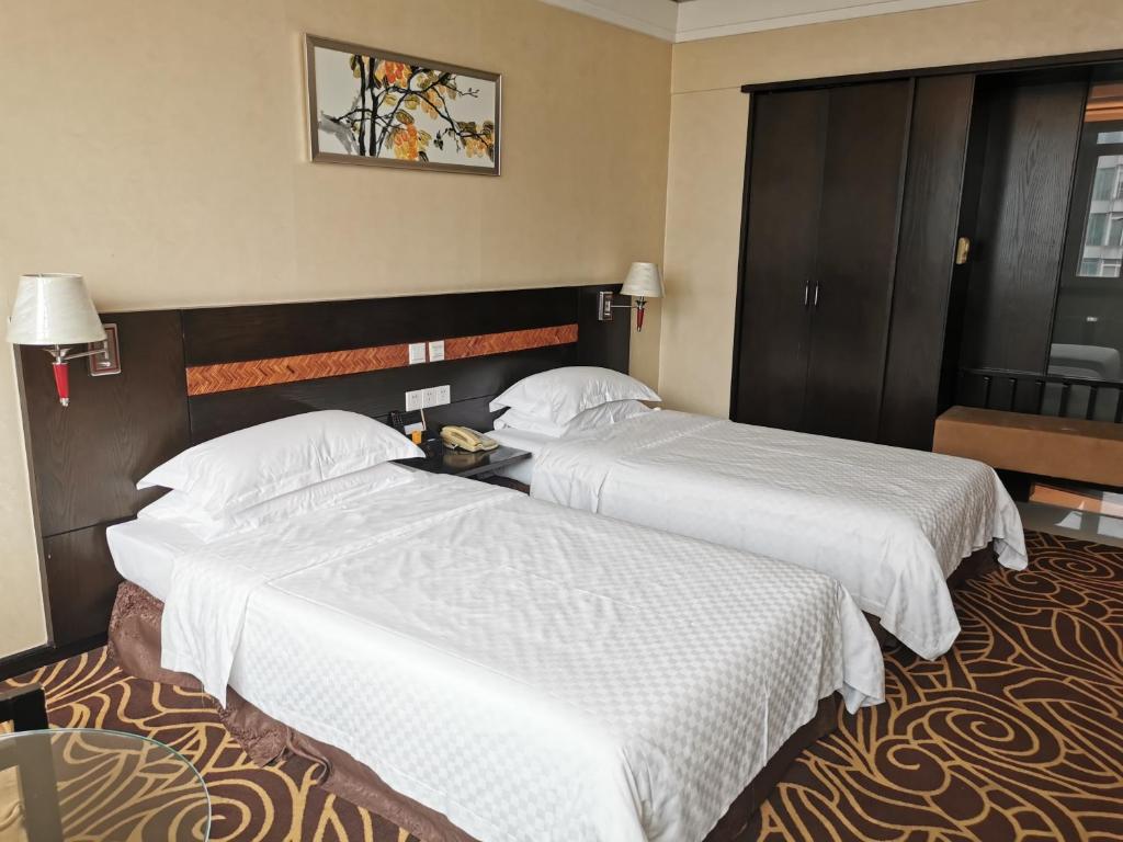 Postel nebo postele na pokoji v ubytování Hua Shi Hotel
