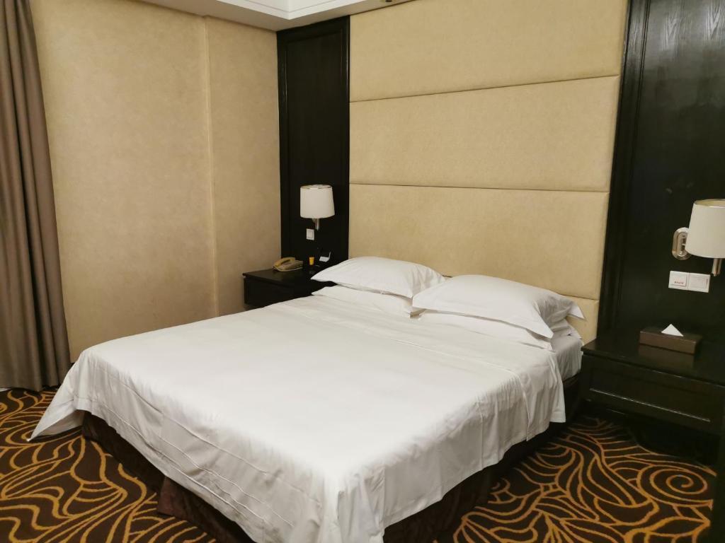 Postel nebo postele na pokoji v ubytování Hua Shi Hotel