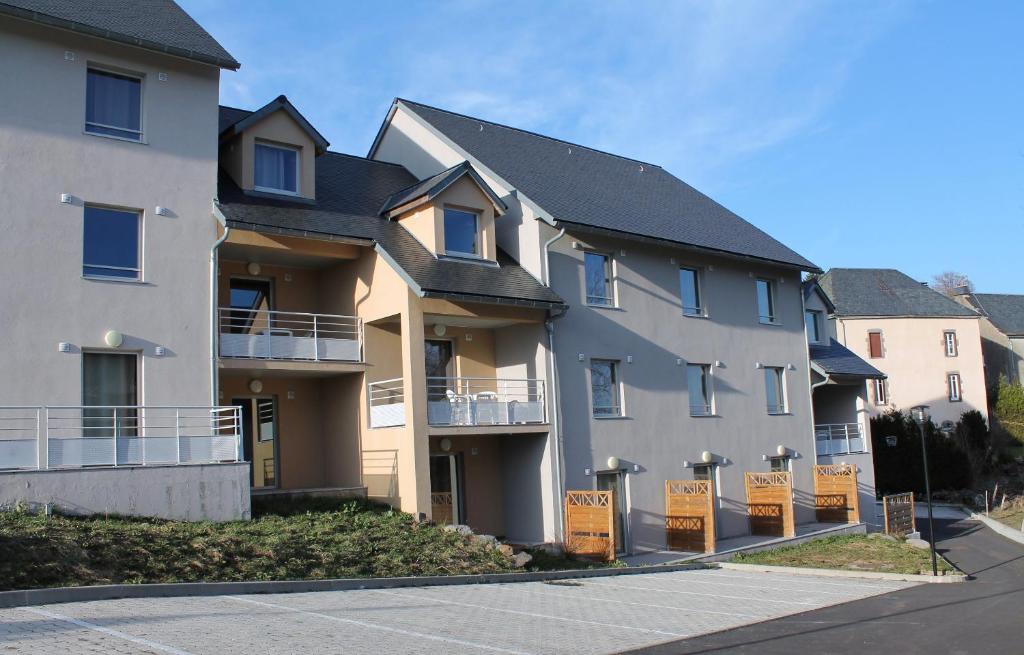 un gran edificio de apartamentos con letreros delante en Aux Balcons du Sancy en Picherande