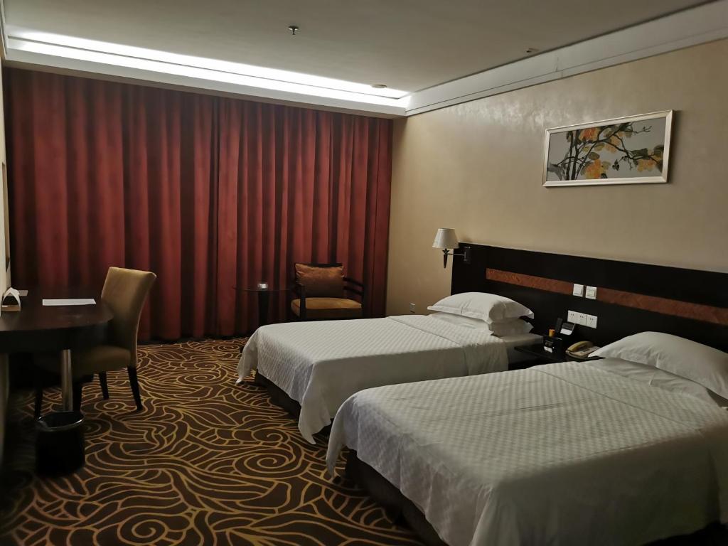 Postel nebo postele na pokoji v ubytování Hua Shi Hotel