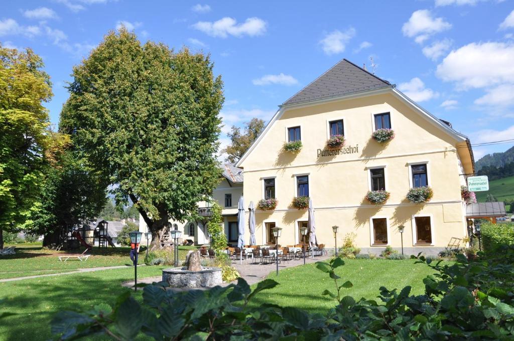 a large white house with a garden and trees at Puttererseehof in Aigen im Ennstal