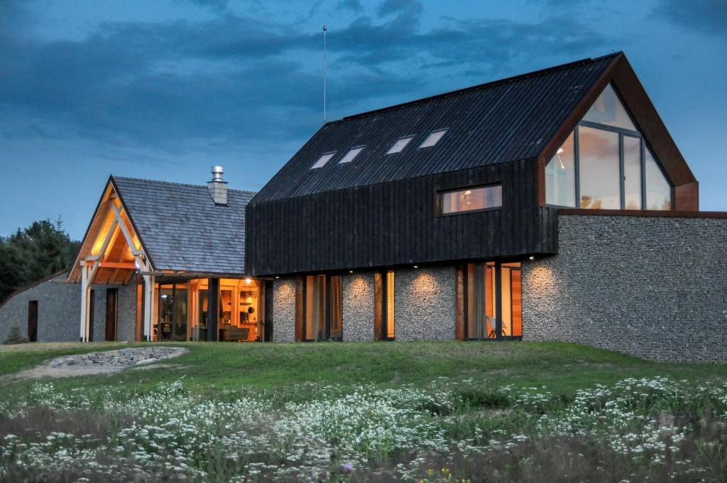 a house with a black roof and windows at Beechtree Property in Izvoare