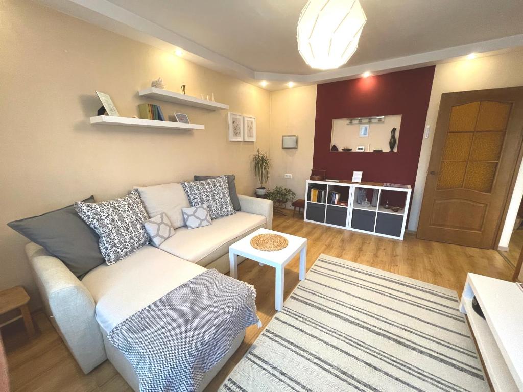 uma sala de estar com um sofá e uma mesa em Cozy Home Apartment Lielvardes, free parking, self check-in em Riga