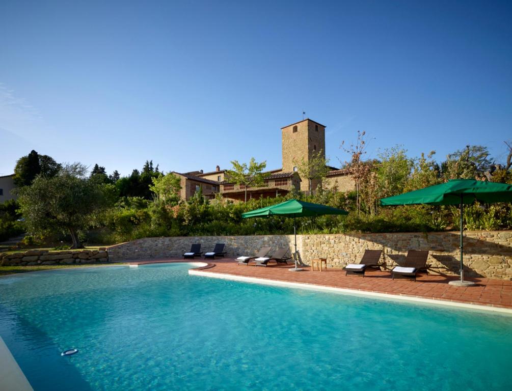 una piscina con sedie e ombrelloni di B&B Borgo Petrognano - Residenza d'Epoca a Barberino di Val dʼElsa