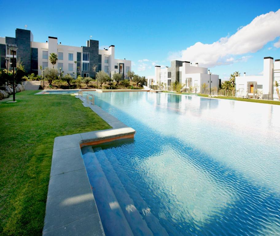 uma grande piscina numa cidade com edifícios altos em El Plantío Golf Resort em Alicante