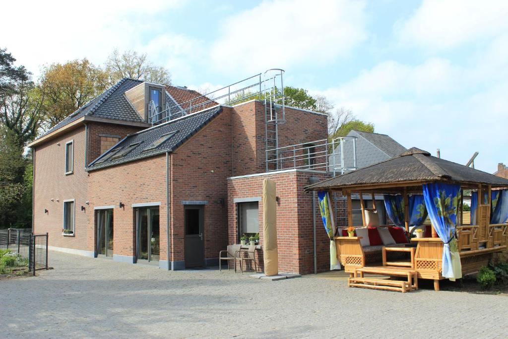 - un grand bâtiment en briques avec un kiosque à côté dans l'établissement B&B Don Genaro, à Dilsen-Stokkem