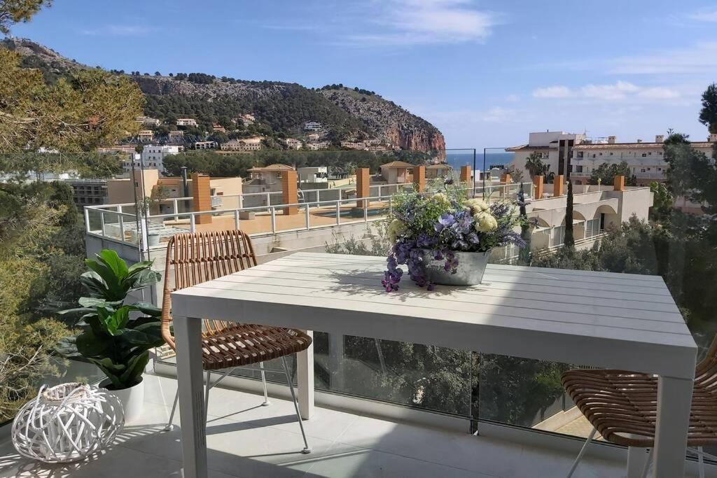 una mesa blanca y sillas en un balcón con vistas en Apartment Cala Torta with Pool and Terrace in Canyamel, en Capdepera