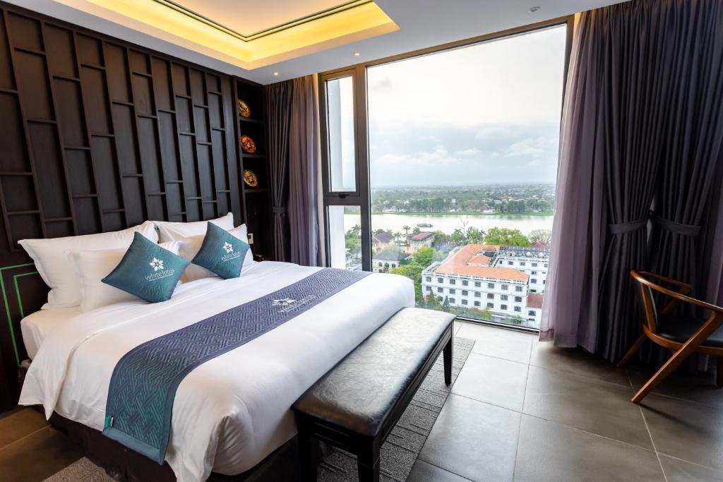 Postel nebo postele na pokoji v ubytování White Lotus Hue Hotel