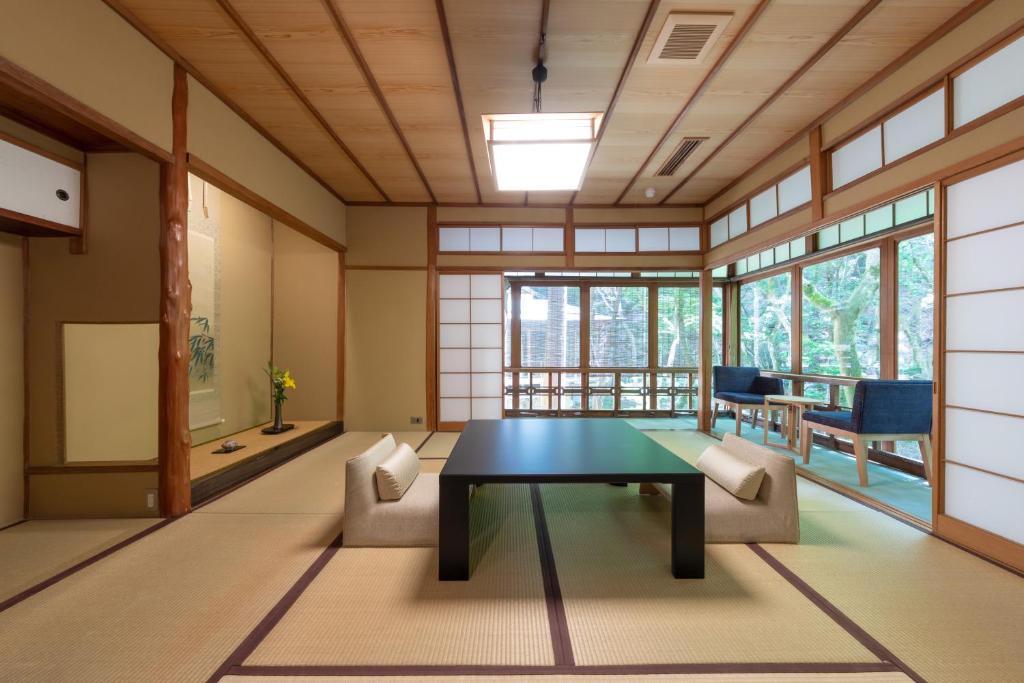 a room with a table and chairs and windows at Tsukihitei in Nara