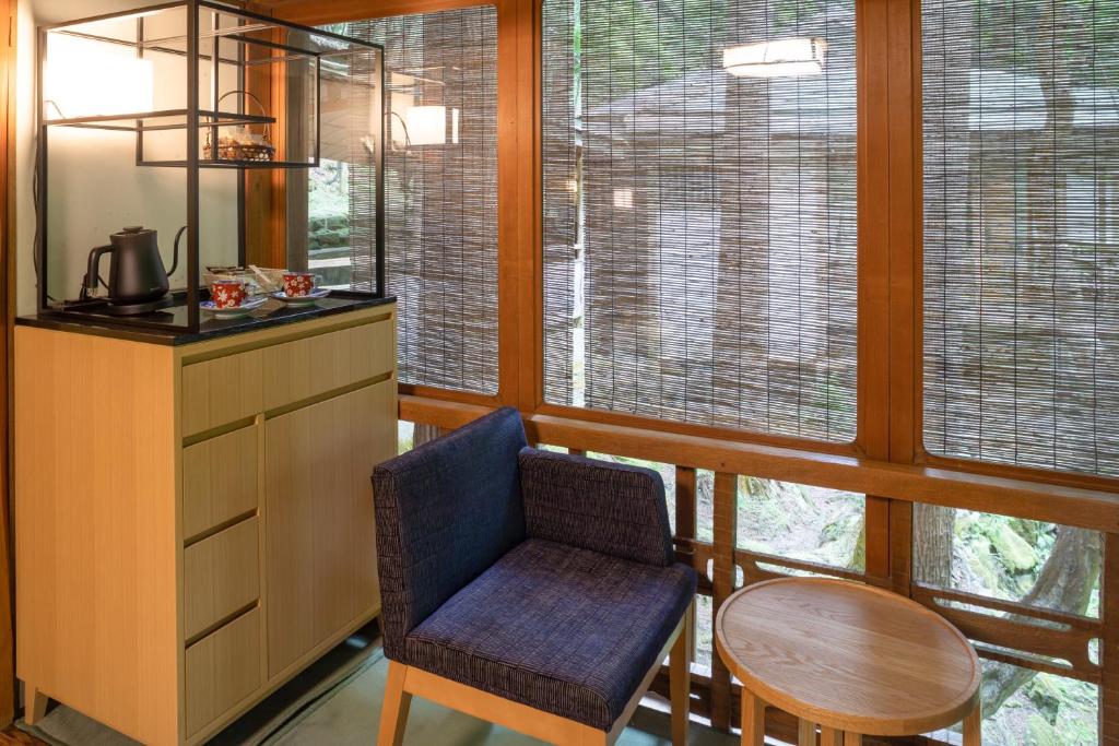 a kitchen with a table and a chair and some windows at Tsukihitei in Nara