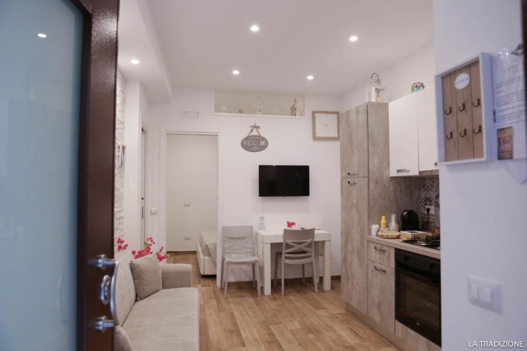 een keuken en een woonkamer met een tafel en een bank bij La Tradizione in Bari