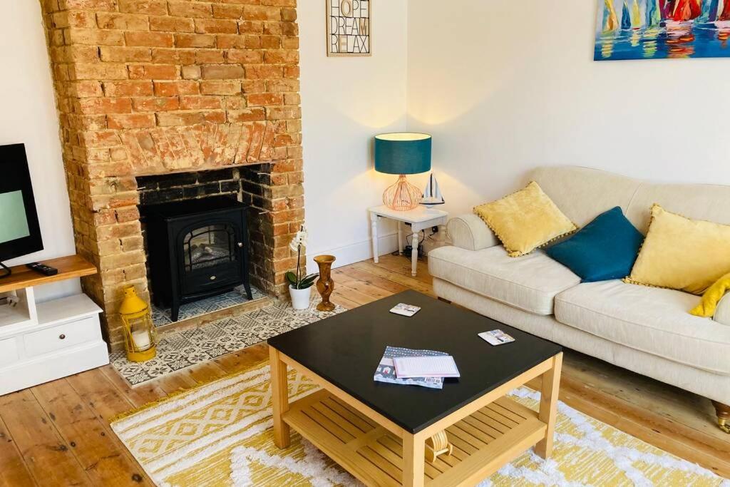 a living room with a couch and a fireplace at No43: Versatile 4BR coastal home with summer house in Cowes