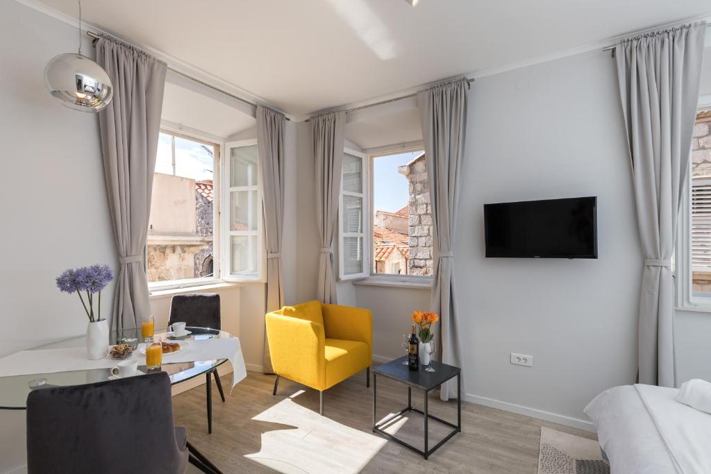 sala de estar con silla amarilla y sofá en Apartments Urbis, en Dubrovnik