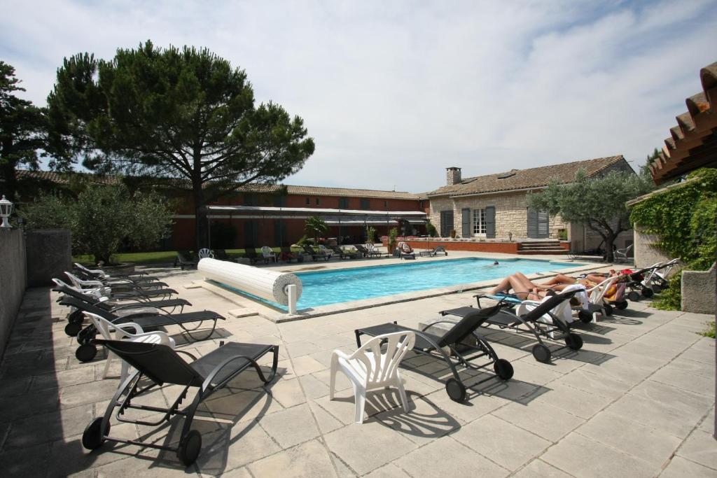 un gruppo di persone sdraiate su sedie a bordo piscina di Hotel Van Gogh a Saint-Rémy-de-Provence