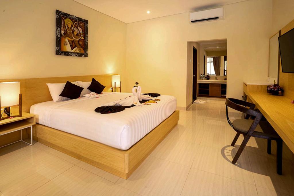 a bedroom with a large white bed and a desk at New Sunari Lovina Beach Resort in Lovina