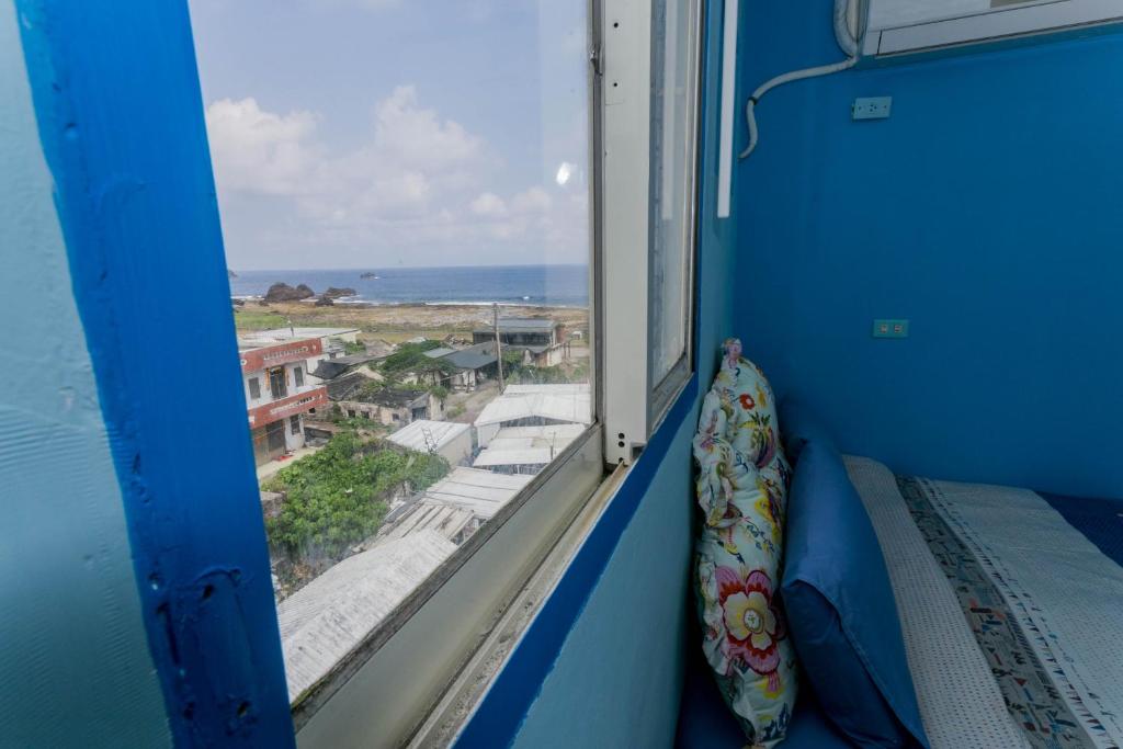 a room with a window with a view of the ocean at Evening Sun B&amp;B in Green Island
