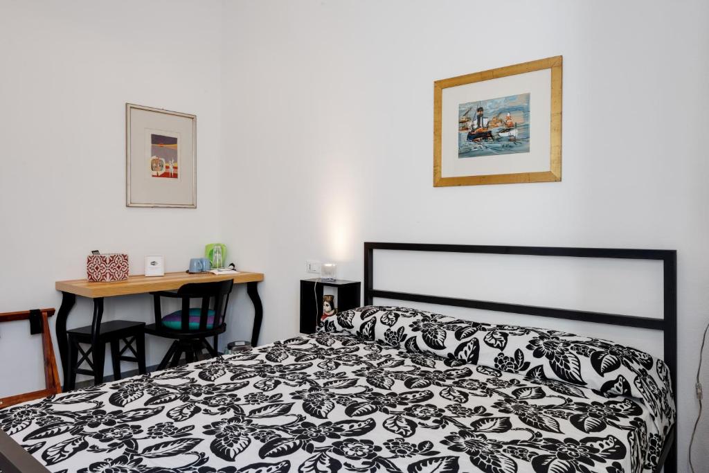 a bedroom with a black and white bed and a desk at Affittacamere Brinn in La Spezia