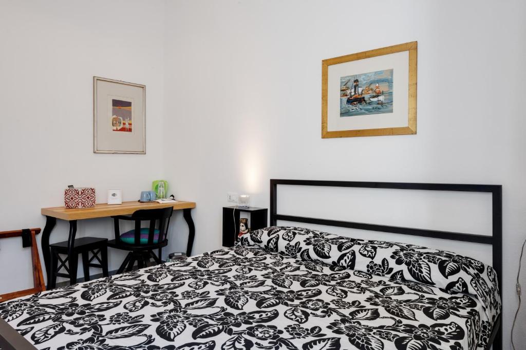 una camera con letto bianco e nero e scrivania di Affittacamere Brinn a La Spezia