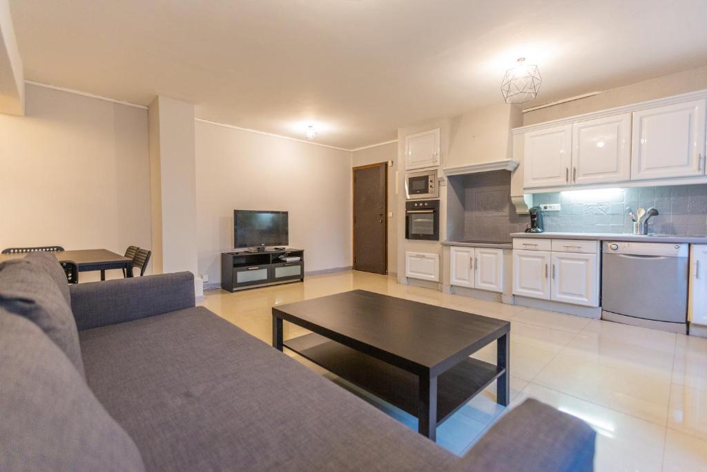 een woonkamer met een bank en een tafel bij Superbe T4 renove spacieux avec stationnement libre et gratuit in Marseille