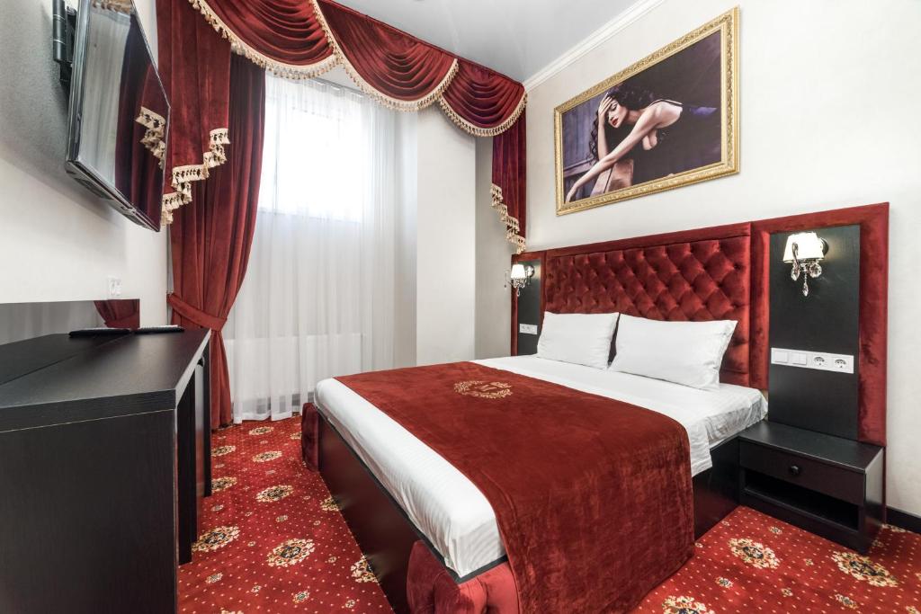 a hotel room with a bed and a television at Apart Hotel D'Monica in Odesa